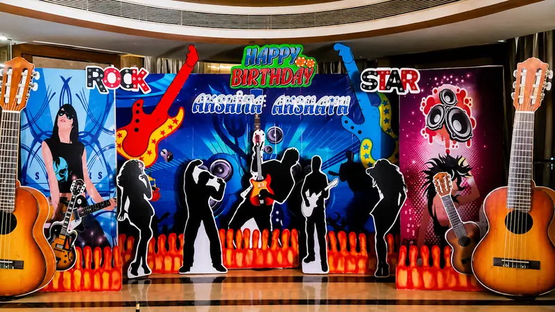 A rock-star themed birthday backdrop with guitars and performer silhouettes